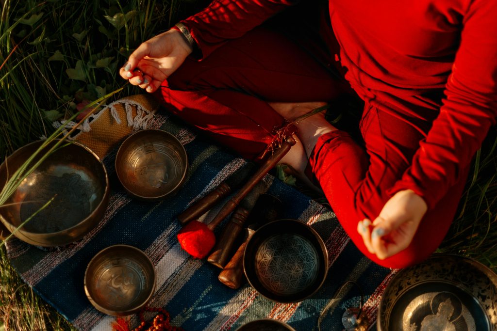 pexels-photo-5416013-5416013 A person meditating outdoors with Tibetan singing bowls, creating a peaceful atmosphere.